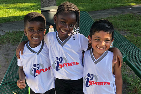 three players in i9 Sports jerseys smile at the camera